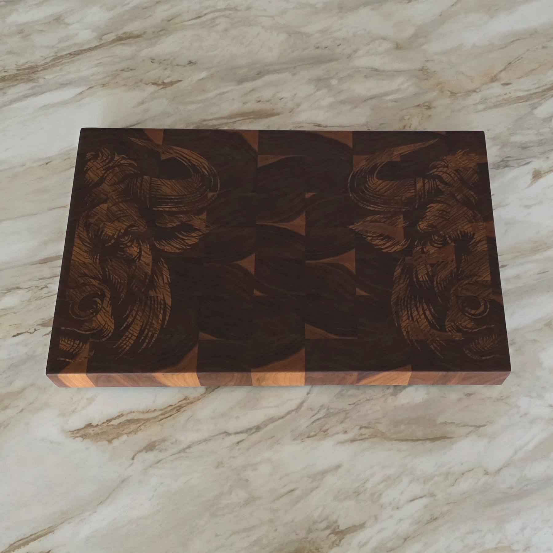 Close-up of engraving cut into a dark walnut end grain cutting board