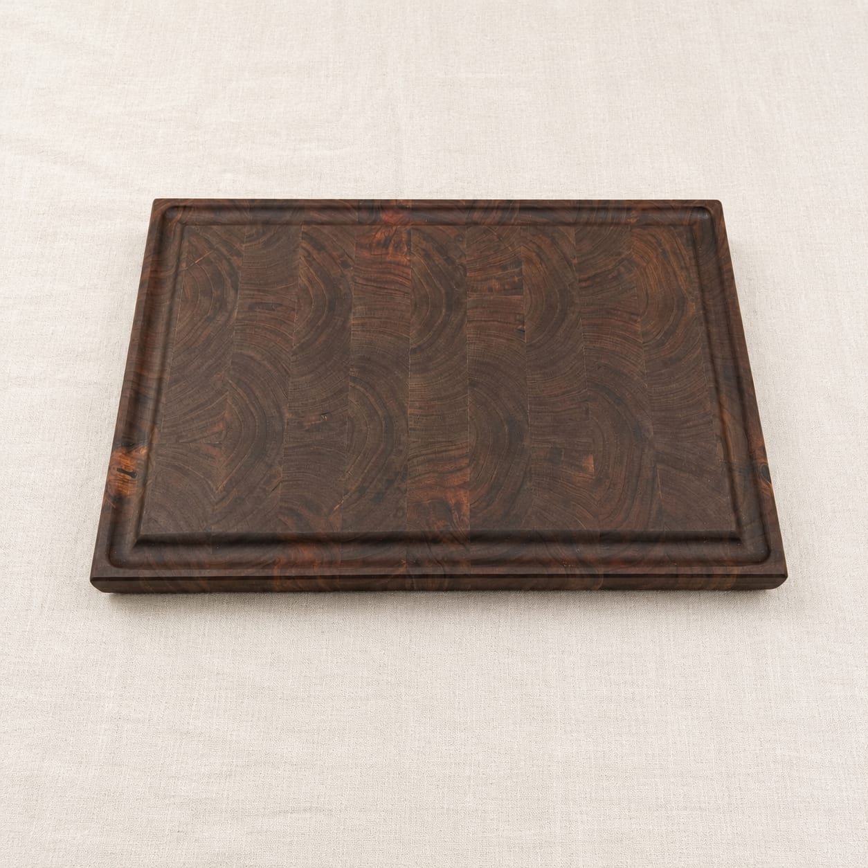 Custom walnut end grain cutting board with a routed juice groove, made in Canada