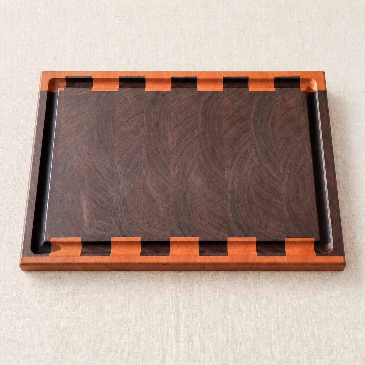 Custom end grain cutting board with a contrasting border, finger notches and a juice groove