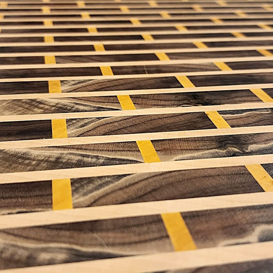 Close-up of pale and yellow accent strips in a custom end grain cutting board