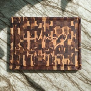 Acacia end grain cutting board with a pale maple inlay set into the surface