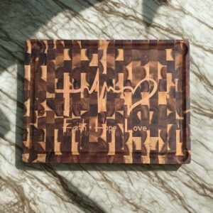 Acacia end grain cutting board with Faith Hope Love maple inlay on marble counter