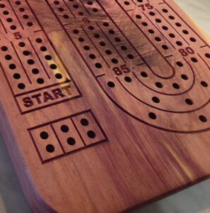 Handcrafted cedar cribbage board with natural grain and cream sapwood