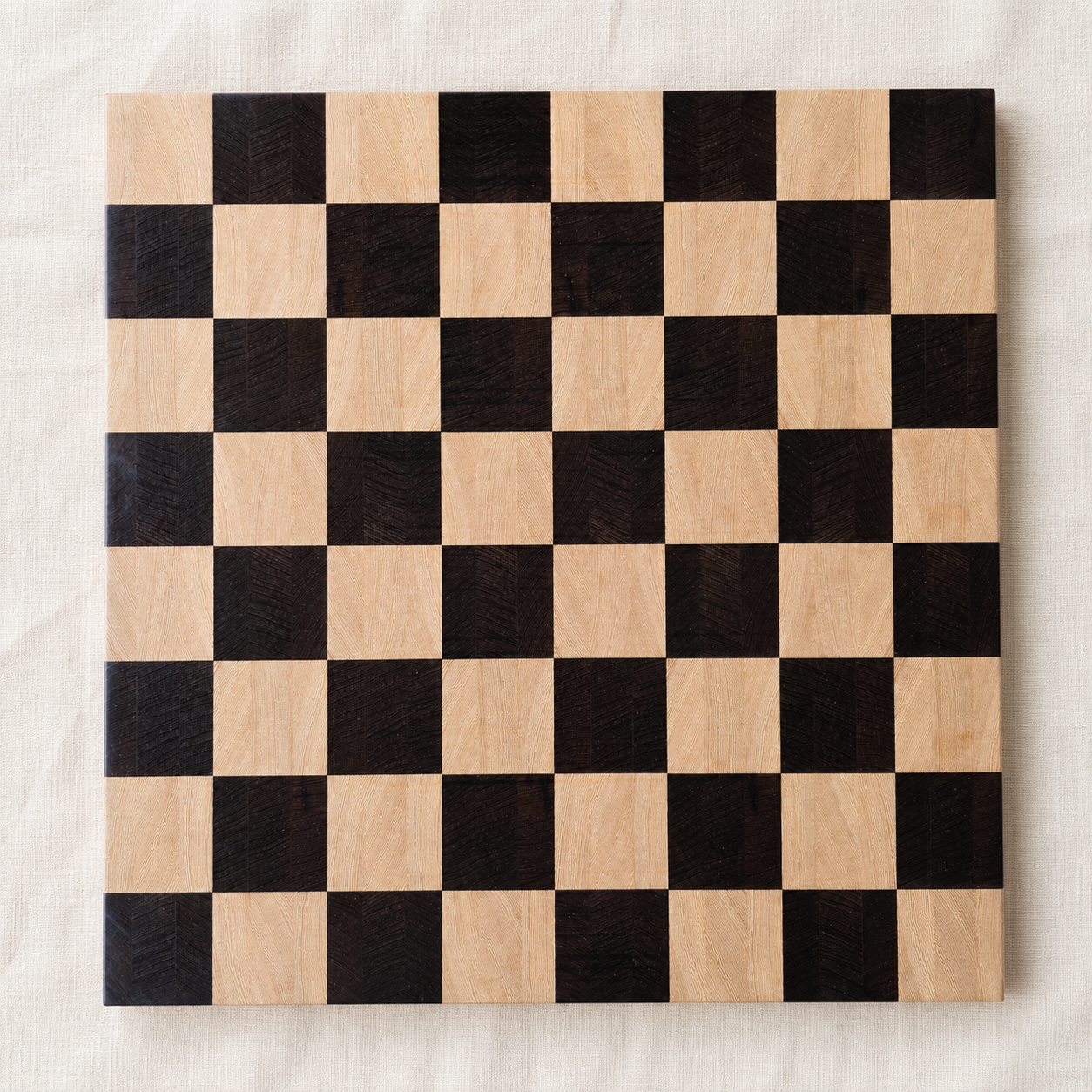 End-grain wenge and Lati chess board, 18 inch, top-down on off-white linen — handmade in Canada by Northern Prairie Woodworks